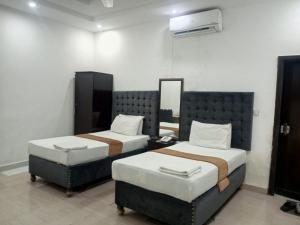 una camera con due letti e uno specchio di Hotel The Tulip a Lahore
