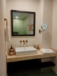 a bathroom with a white sink and a mirror at Hotel Casa de la Acequia in Santa Marta