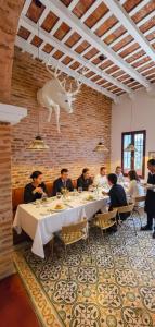 a group of people sitting at a table in a restaurant at Hotel Casa de la Acequia in Santa Marta