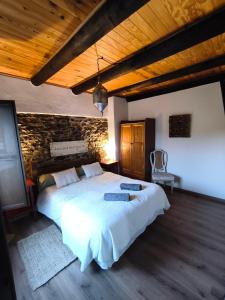 a bedroom with a large bed and a brick wall at A Boira Rural in Osia
