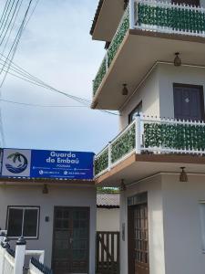 een gebouw met een balkon en een bord erop bij Pousada Guarda do Embaú in Guarda do Embaú