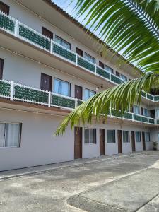 een gebouw met een palmboom ervoor bij Pousada Guarda do Embaú in Guarda do Embaú