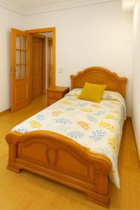 MarinaMar Camariñas في كامارينياس: غرفة نوم بسرير خشبي عليها وسادة صفراء