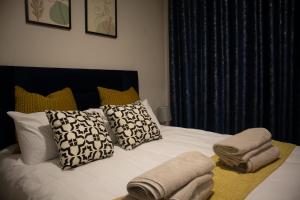 Serene Retreat في ميدراند: سرير ابيض عليه مخدات ومناشف