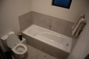 Serene Retreat في ميدراند: حمام مع مرحاض وحوض استحمام