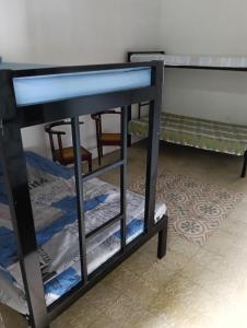 a black bunk bed in a room with a table at Casa familiar con piscina privada in Agua de Dios