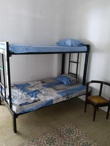 a bunk bed in a room with a chair at Casa familiar con piscina privada in Agua de Dios