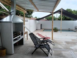 a patio with two chairs and a stove at Casa familiar con piscina privada in Agua de Dios