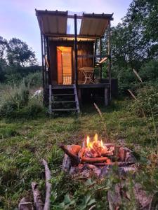 Tiny house au pied du Vercors في Saint-André-en-Royans: نار المخيم أمام منزل صغير