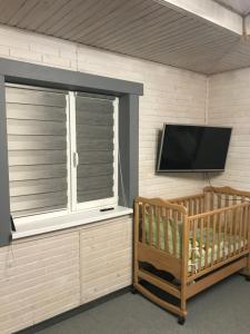 Una habitación con una ventana y un televisor de pantalla plana. en Ромашка, en Sheshory