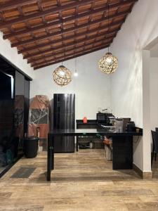 a kitchen with a black table and a refrigerator at Casa Paraty espaçosa próximo ao centro histórico in Paraty