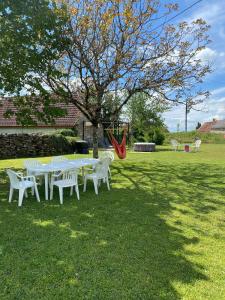 una mesa y sillas en un patio con un árbol en Maison quercynoise Coeur du causse 4 à 8 pers, en Durbans