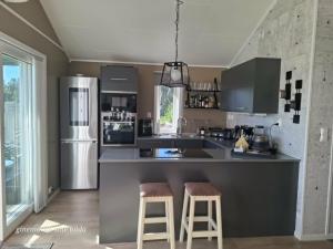 a kitchen with a refrigerator and two bar stools at Mettes holiday home in Silsand +18 photos