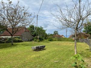 un parque con un banco de piedra en el césped en Maison quercynoise Coeur du causse 4 à 8 pers, en Durbans