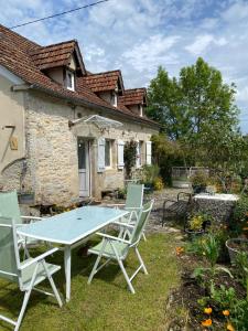 Una mesa y sillas frente a una casa en Maison quercynoise Coeur du causse 4 à 8 pers, en Durbans