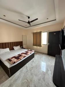 a bedroom with a bed and a ceiling fan at Hotel Kingdom - 3 minutes From Golden Temple in Amritsar
