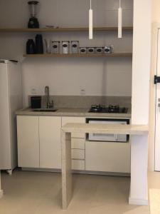a kitchen with white cabinets and a counter top at Baltico302 in Capão da Canoa
