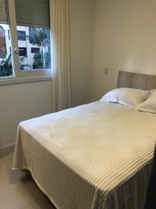 a bed in a bedroom with a window at Baltico302 in Capão da Canoa