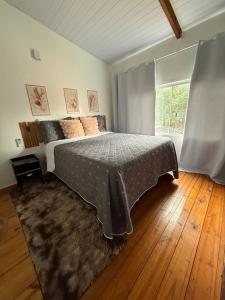 a bedroom with a bed and a large window at Cantinho Santiago in Alto Paraíso de Goiás +29 photos