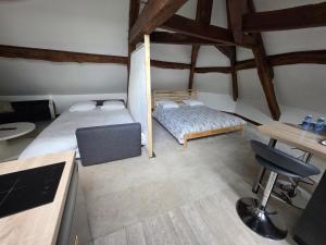 a small room with two beds and a desk at Relais Saint-Laurent - Chevreuse in Chevreuse