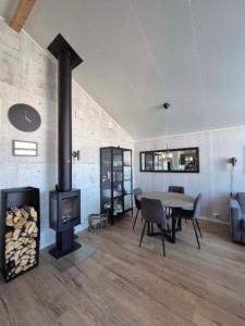 a living room with a wood stove and a table at Mettes holiday home in Silsand
