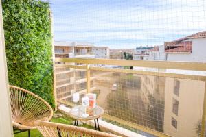 a balcony with a table and chairs on a balcony at Maïmo Cosy Appartement rénové Centre Ville 300m plage, Clim, Parking in Sainte-Maxime