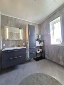 a bathroom with a sink and a large mirror at Mettes holiday home in Silsand +18 photos