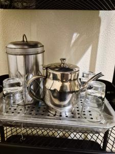 a metal tea pot and glasses on a shelf at Studio idéal pour vos sejours in Dakar +15 photos