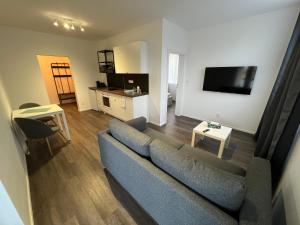 a living room with a blue couch and a television at Apartmány ASTRA in Cheb