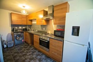 een keuken met houten kasten en een witte koelkast bij Long Barn House - Andover in Enham-Alamein +13 foto's