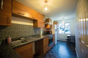 a kitchen with wooden cabinets and a sink and a window at Long Barn House - Andover in Enham-Alamein