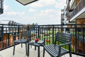 a balcony with two chairs and a table with fruit on it at BelMare Aqua Resort by Solarento in Międzyzdroje