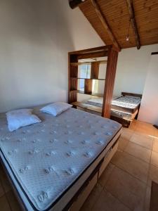 a bedroom with two beds and a mirror at Casas no Centro Histórico de Garopaba in Garopaba +43 photos