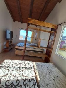a bedroom with two bunk beds and a television at Casas no Centro Histórico de Garopaba in Garopaba