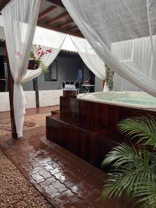 a room with a hot tub and a table with chairs at Cantinho Santiago in Alto Paraíso de Goiás