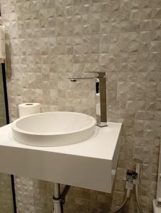 Un lavabo de baño blanco con grifo. en City Urban Hotel, en Tirana 8 fotos más