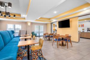 un soggiorno con divano, tavoli e sedie di Hampton Inn - Monticello a Monticello