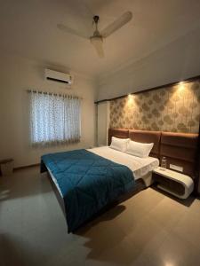 a bedroom with a large bed with a blue blanket at Tranquil Trails-Sharvari Villa-Nashik in Nashik +94 photos