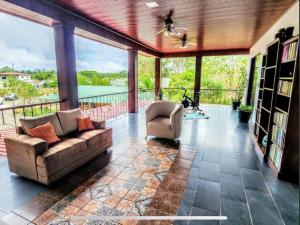 a living room with a couch and a chair on a balcony at Paseo de Damitas in Quepos