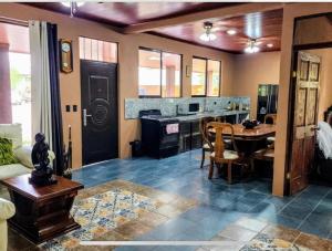 a living room with a table and a kitchen at Paseo de Damitas in Quepos
