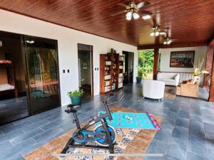a room with a gym with a exercise bike on the floor at Paseo de Damitas in Quepos