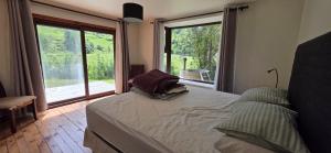 a bedroom with a bed and a large window at Casa campo en plena naturaleza 3 dormitorios y 2 baños in Lago Ranco
