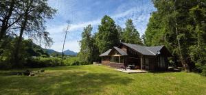 a small cabin in the middle of a grass field at Casa campo en plena naturaleza 3 dormitorios y 2 baños in Lago Ranco