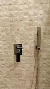 baño con ducha con cuchillo en la pared en City Urban Hotel, en Tirana