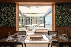 Un comedor con una mesa y un gran ventanal. en Radisson Hotel Colonia del Sacramento, en Colonia del Sacramento