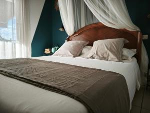 a bedroom with a large bed with a wooden headboard at GîTE MAYO & HYLODES'S SONG in Bouillante