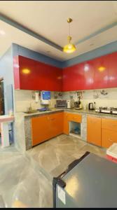 诺伊达DM Farmhouse的厨房配有橙色橱柜和台面