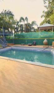 诺伊达DM Farmhouse的一座铺有木地板的大型游泳池