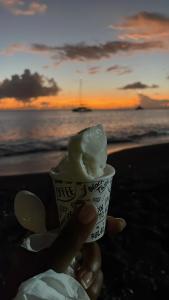 a person holding a cup of ice cream at the beach at L essenCiel in Saint-Claude