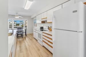 a kitchen with white cabinets and a white refrigerator at CAC-3B - Cobia in Buxton